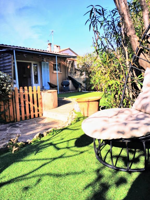 a yard with a chair and a table in the grass at Studio jardin privatif 300m de la plage in Sainte-Maxime