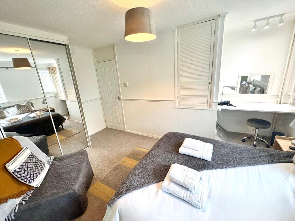 キドリントンにあるHomely 2 bedroom house, parkingのベッドとソファと机のある寝室