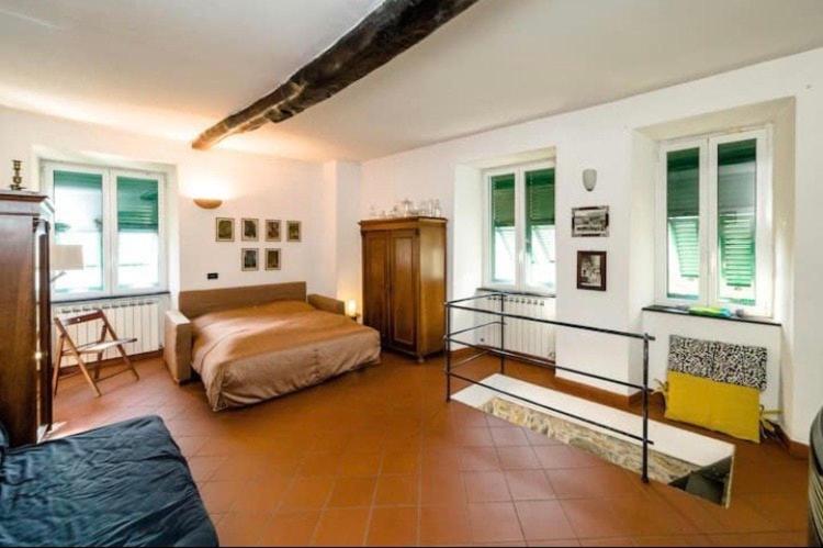 une chambre avec un lit dans une pièce avec des fenêtres dans l'établissement Rustico tra gli Ulivi, à Rapallo