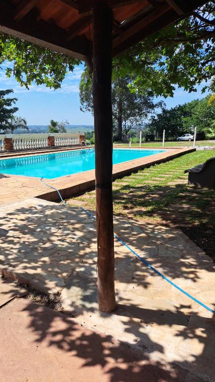 a picnic table next to a swimming pool at Chácara Samambaia Piracicaba in Piracicaba