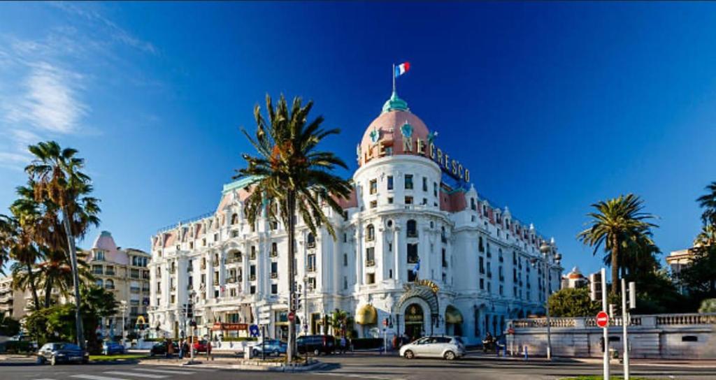 un bâtiment blanc avec un drapeau dessus dans l'établissement Chic Flat Near the Beach, à Nice