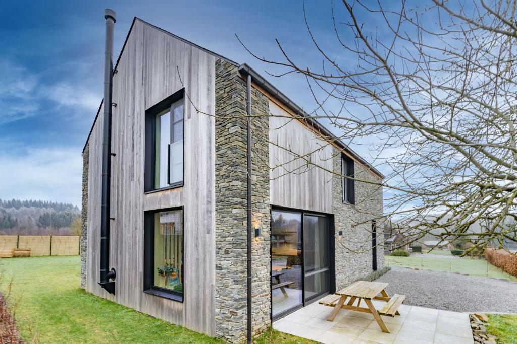 a house with a stone wall and windows at Nature'Hayette in Tenneville