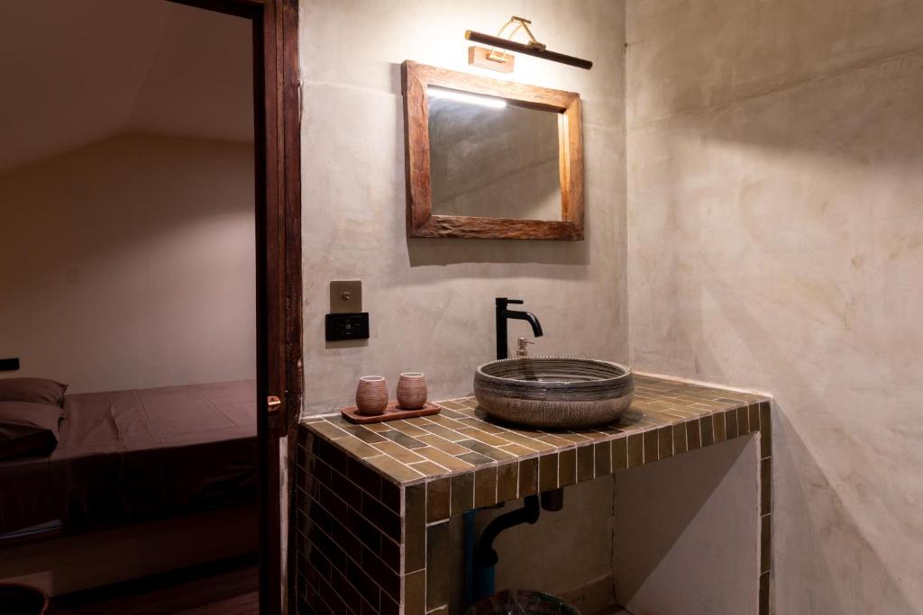 un bagno con lavandino e specchio di Ḥokma Boutique Hotel & Tropical Lounge a Phi Phi Don