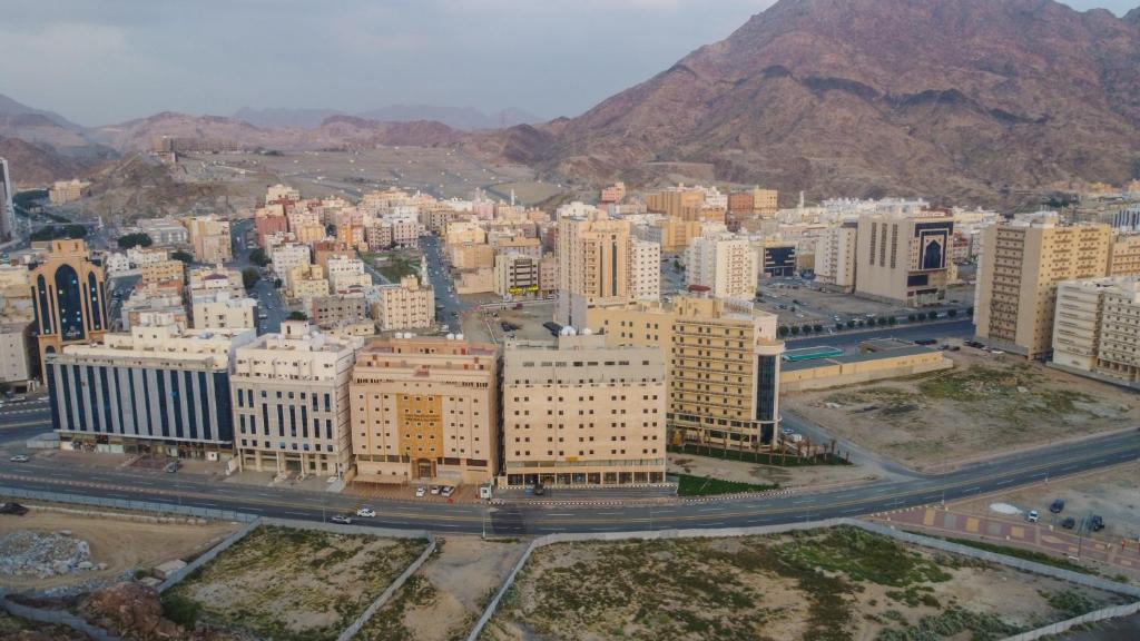 Durrat AlJawharah Hotel Makkah في مكة المكرمة: اطلالة جوية على مدينة بها مباني وجبال