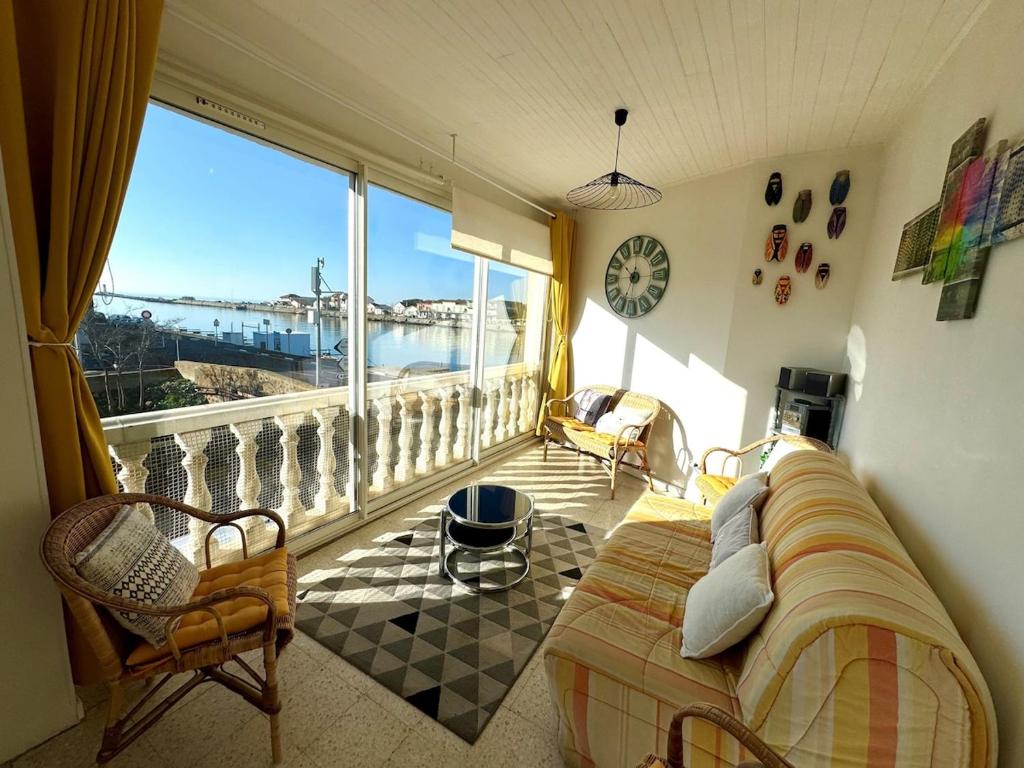 un salon avec un lit et une grande fenêtre dans l'établissement Appartement - Le Grau d'Agde, au Grau-dʼAgde