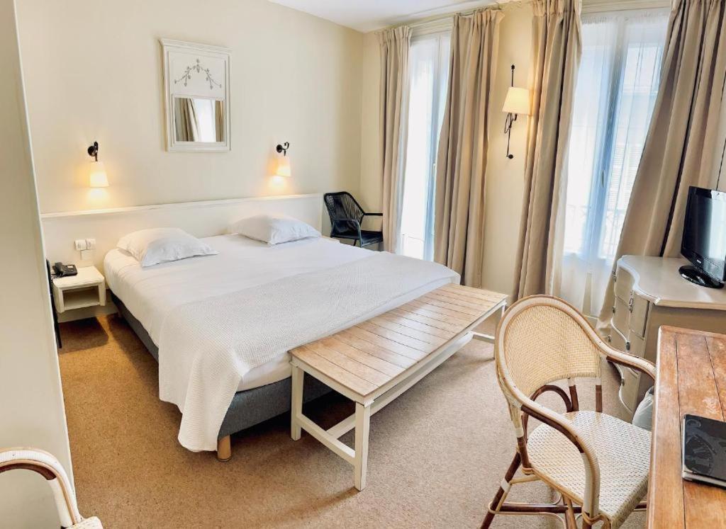 Postel nebo postele na pokoji v ubytování Hotel & Restaurant LE CENTRAL TROUVILLE