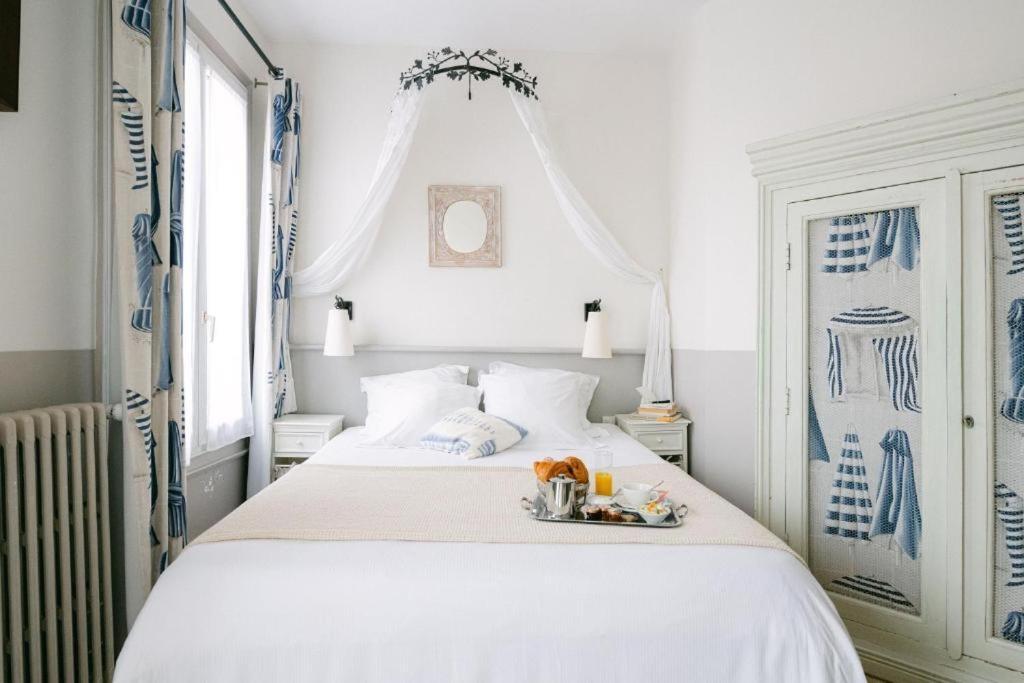 Postel nebo postele na pokoji v ubytování Hotel & Restaurant LE CENTRAL TROUVILLE
