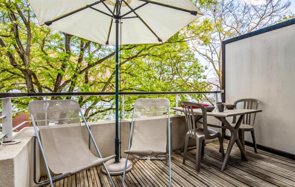 un patio avec une table, des chaises et un parasol dans l'établissement Cozy Apartment In La Rochelle With Wifi, à La Rochelle