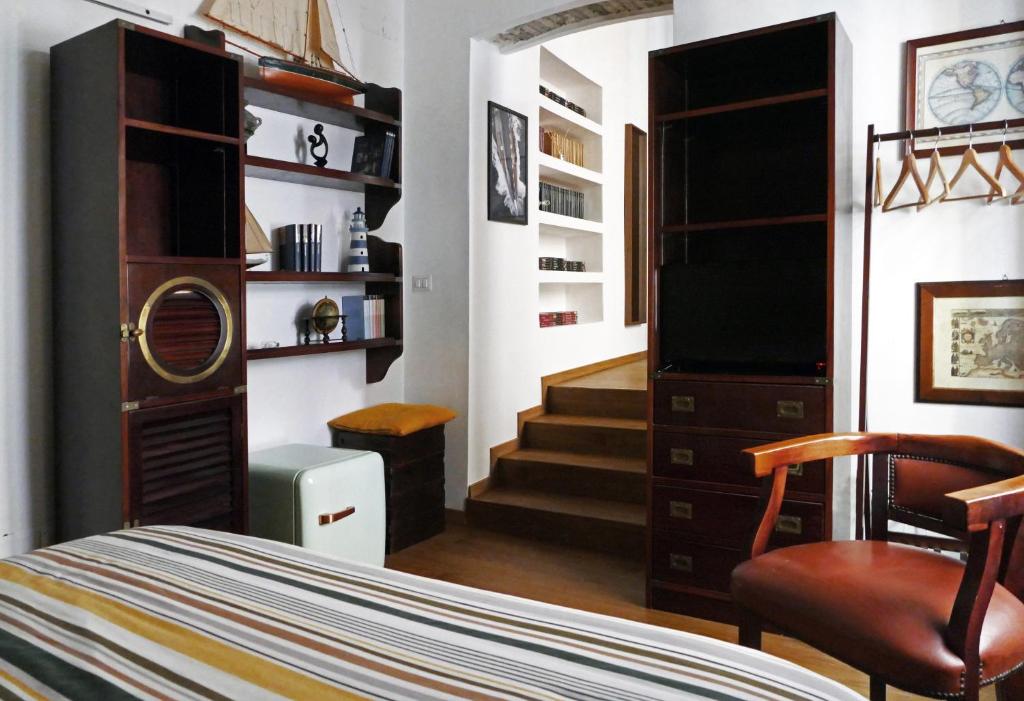 a bedroom with a bed and a chair and a television at Tosti 79 in Formia