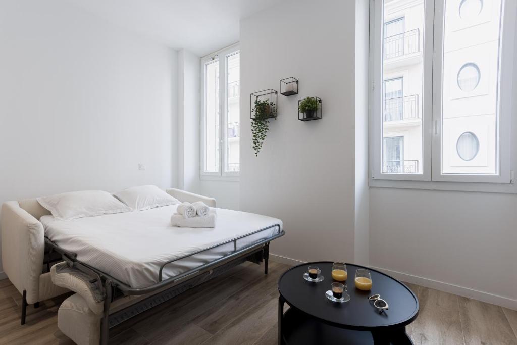 une chambre blanche avec un lit et une table dans l'établissement 