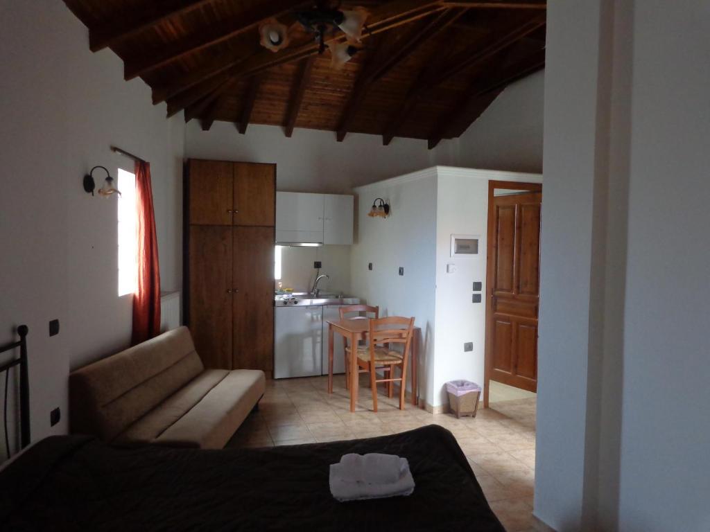 a bedroom with a couch and a kitchen with a table at Alonaki Guesthouse in Plátanos