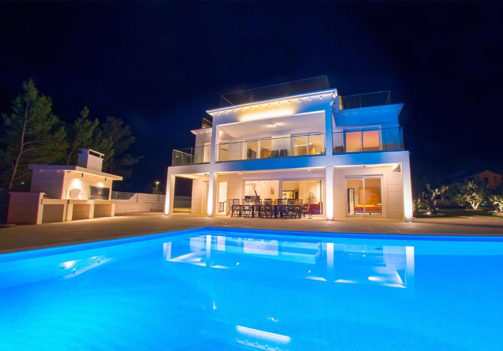 a villa with a swimming pool at night at Villa Anto in Pridraga