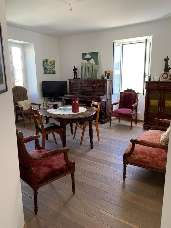 - un salon avec une table, des chaises et un piano dans l'établissement Appartement Vezzani Centre Corse, à Vezzani