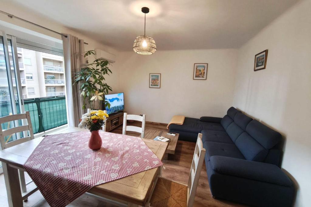 un salon avec un canapé bleu et une table dans l'établissement Charming T3 with balconies in Ajaccio, à Ajaccio