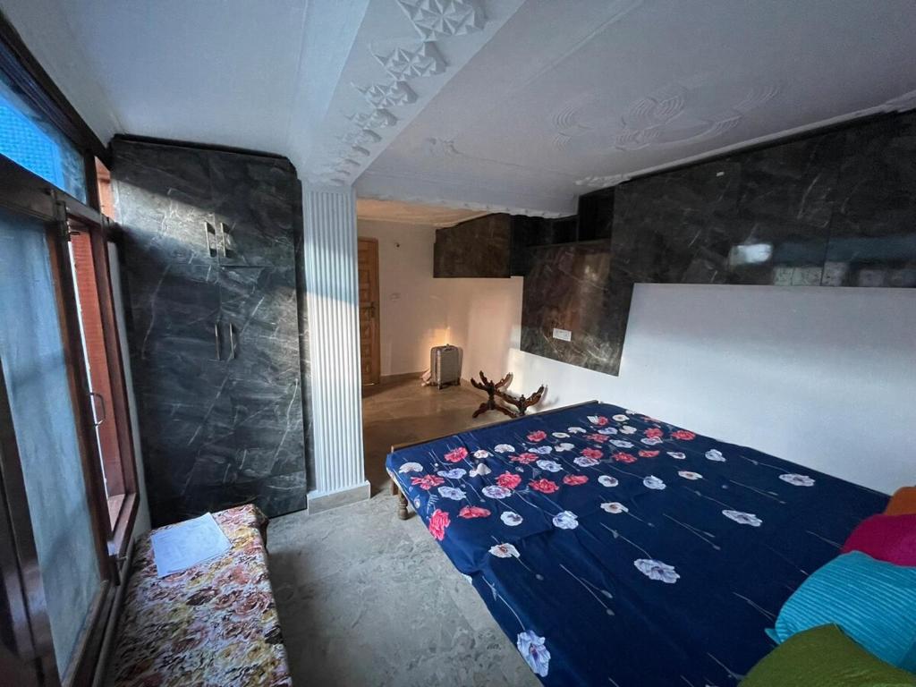a bedroom with a blue bed with flowers on it at Ariva Home Stay in Solan