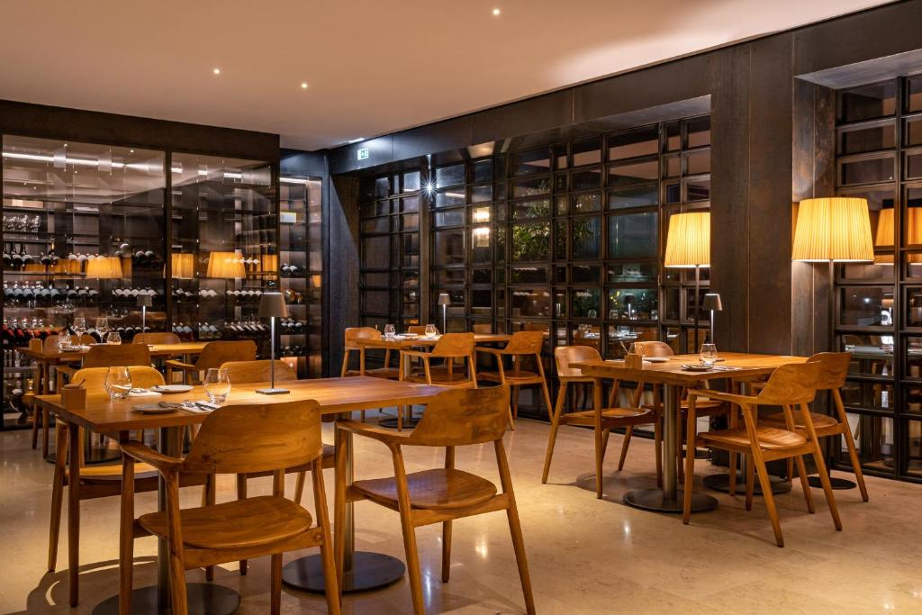 a restaurant with wooden tables and chairs and shelves at 3HB Faro in Faro