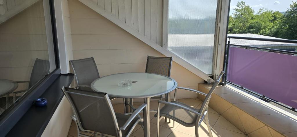 Una mesa y sillas en el balcón de una casa. en stay with friends Trier 2, en Trier