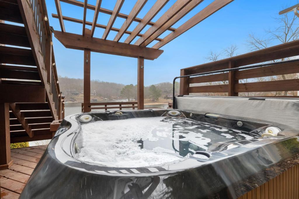 a hot tub on the deck of a house at Dock Holiday - Hot Tub - Private Dock in Bella Vista