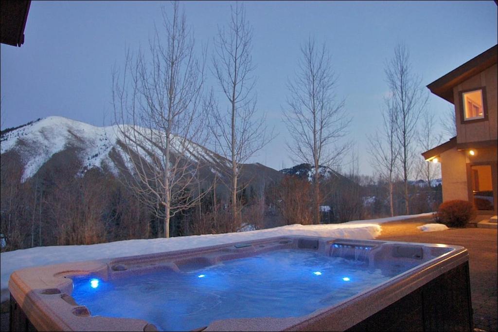a hot tub in a yard with a snow covered mountain at Game Room, Outdoor Hot Tub, Two Kitchens, Perfect For Large Families in Ketchum
