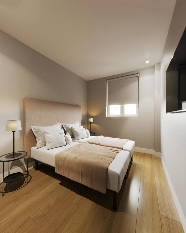 a bedroom with a large bed with white pillows at Apartamentos Ovetum in Oviedo