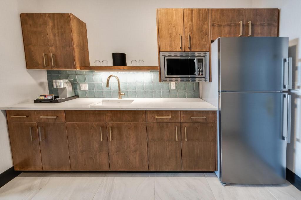 a kitchen with a stainless steel refrigerator and wooden cabinets at Allred Hotel in Newport