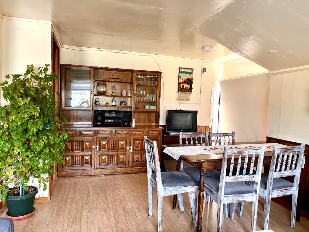 une salle à manger avec une table, des chaises et une télévision dans l'établissement Casa Vintage Puerto Varas, à Puerto Varas