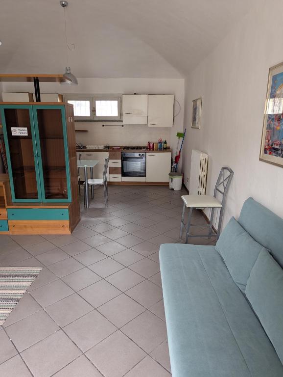 a living room with a blue couch and a kitchen at La pinacoteca in Asti