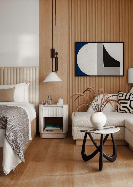 a bedroom with a bed and a couch and a table at One&Only Aesthesis, Athens in Athens