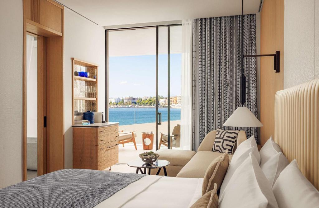 a bedroom with a bed and a view of the ocean at One&Only Aesthesis, Athens in Athens