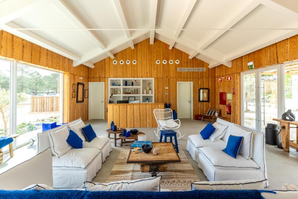 a living room with white couches and blue pillows at La Réserve-Comporta by Terresens in Carvalhal