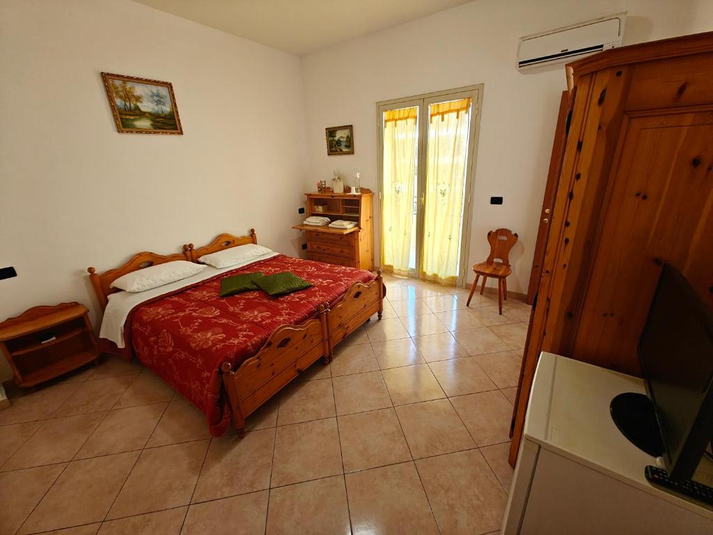 una camera da letto con un letto e una TV di Al Cedir a Reggio di Calabria