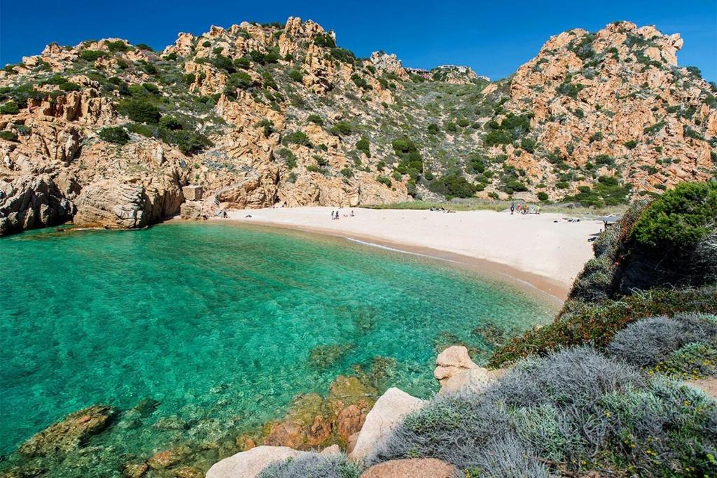 Villa Smeralda Costa Paradiso Sardinia holidays في كوستا باراديسو: شاطئ مع مجموعة من الناس في الماء
