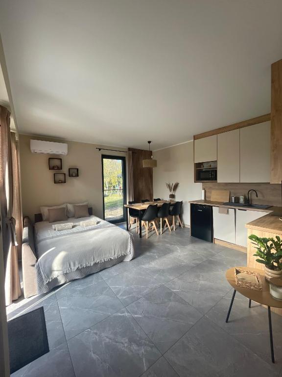 a bedroom with a bed and a kitchen with a table at Natura Home in Skoki