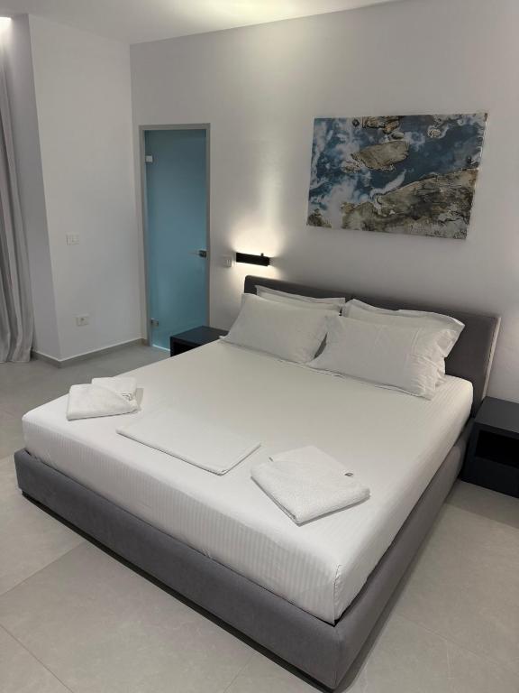 a bedroom with a large bed with white sheets and pillows at Adele Hotel Ksamil in Ksamil