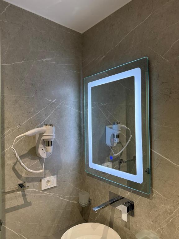 a bathroom with a mirror and a toilet at Adele Hotel Ksamil in Ksamil