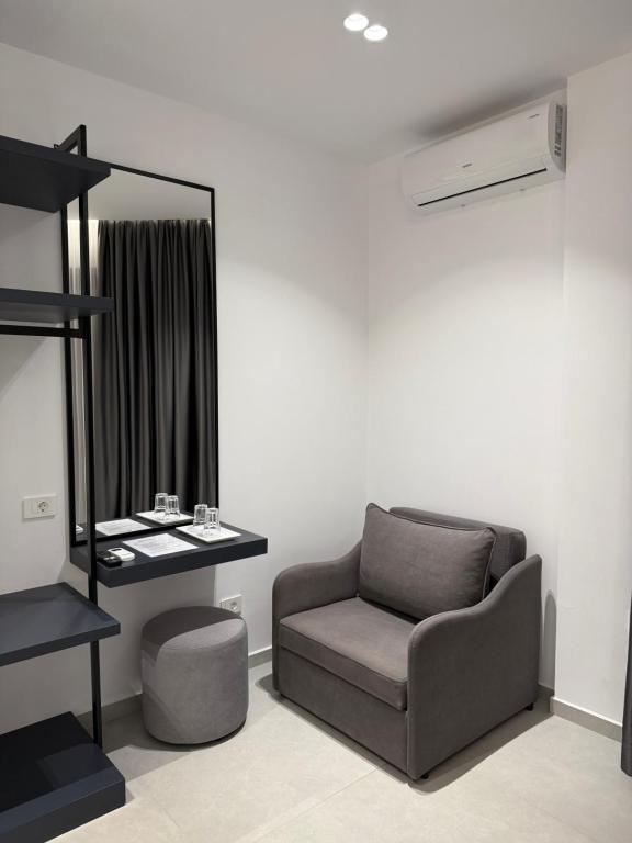 a living room with a chair and a mirror at Adele Hotel Ksamil in Ksamil