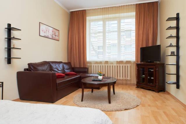 a living room with a leather couch and a coffee table at Old Town Apartments in Vilnius