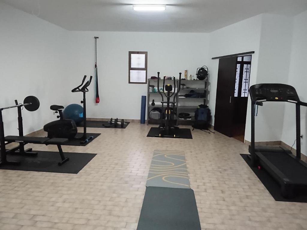 Un gimnasio con varios equipos de ejercicio en una habitación. en Viva Villa, en Gaula