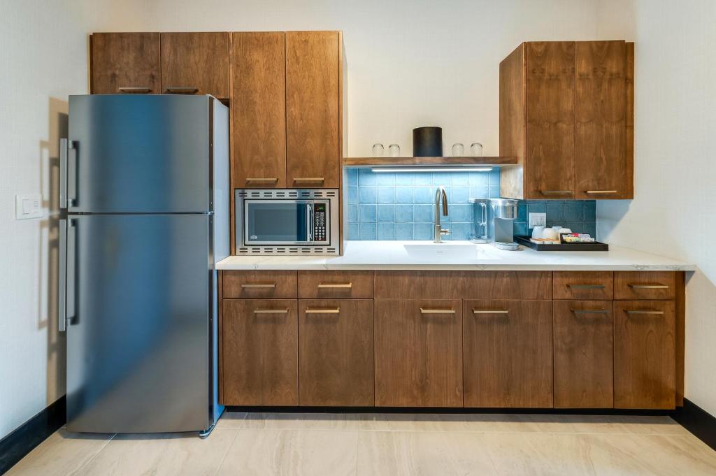 a kitchen with a stainless steel refrigerator and wooden cabinets at Allred Hotel in Newport