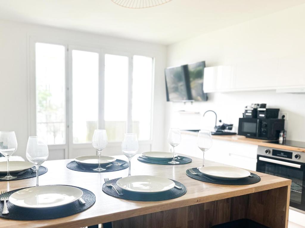 une cuisine avec une table avec des assiettes et des verres à vin dans l'établissement La parenthèse partagée, à Brest