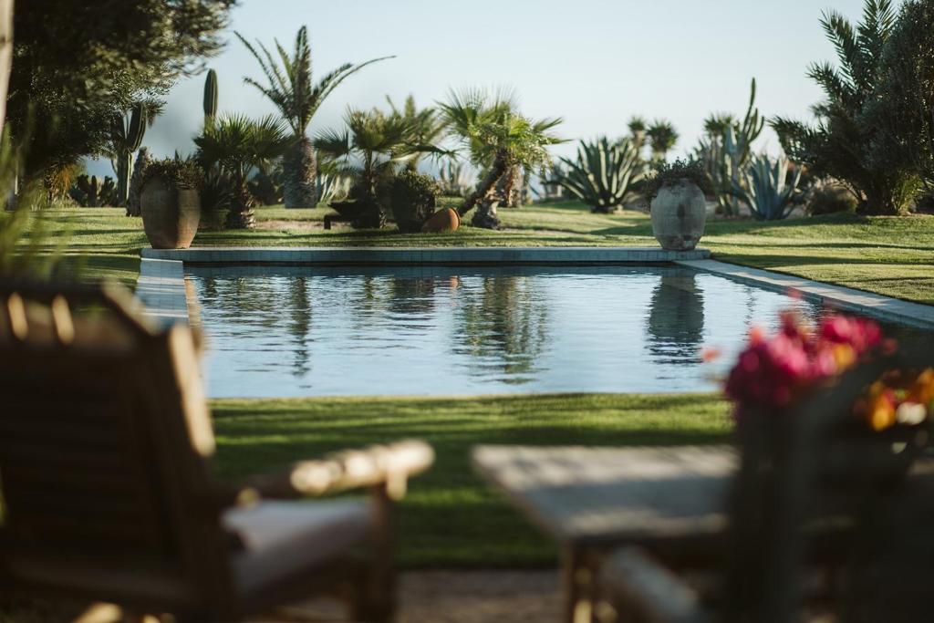 a swimming pool in a yard with a table and chairs at La Pausa in Tías