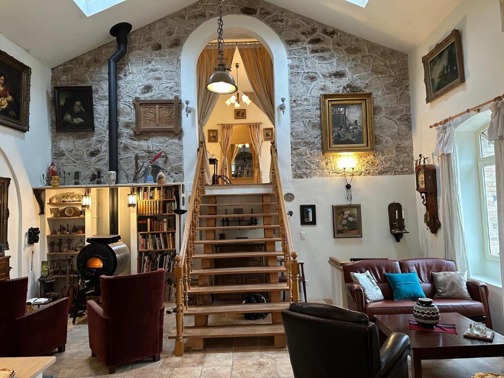 un salon avec un escalier en colimaçon dans un mur en pierre dans l'établissement Grande maison, bordure forêt, La Citadelle, à Molières-sur-Cèze