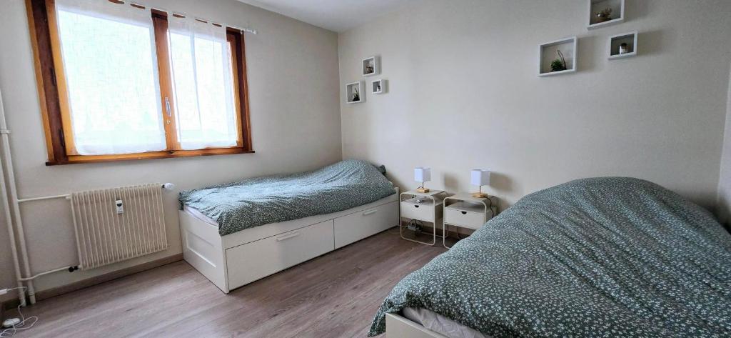 une chambre avec deux lits et une fenêtre dans l'établissement L 'écrin, à Thonon-les-Bains