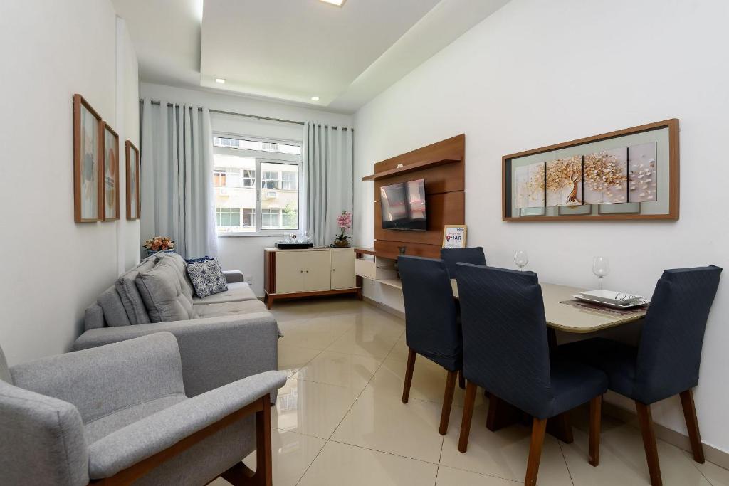a living room with a table and chairs and a couch at Quarto&Sala Completo a 300m da Praia | NSC 386/402 in Rio de Janeiro