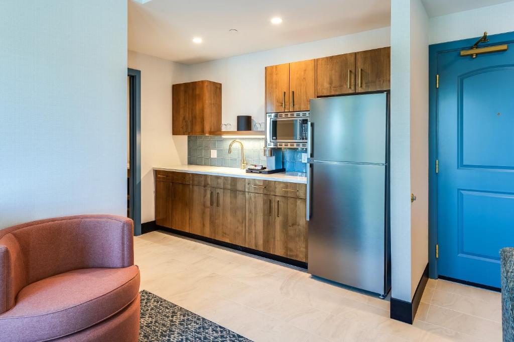 a kitchen with a refrigerator and a chair at Allred Hotel in Newport