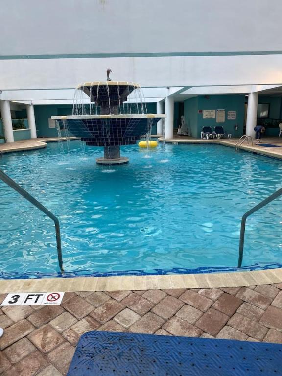 a swimming pool with a fountain in a building at Laidback n Lazy at Landmark Resort in Myrtle Beach