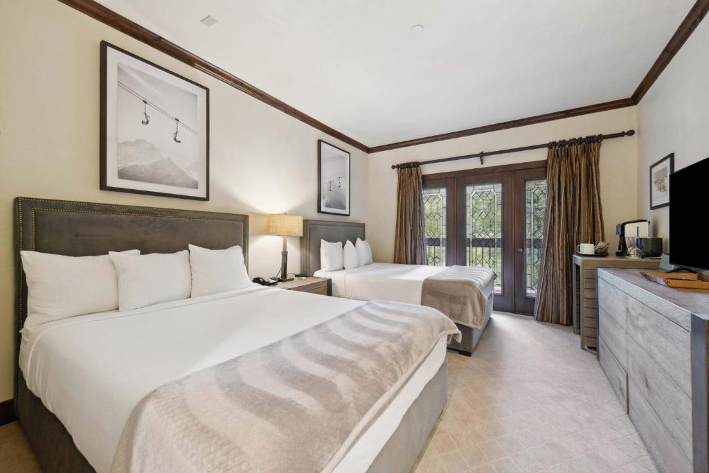 a hotel room with two beds and a television at The Charter at Beaver Creek C115 in Beaver Creek
