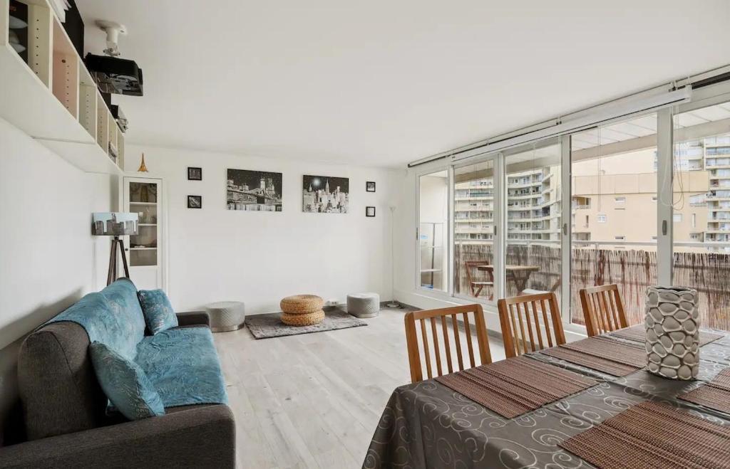 ein Wohnzimmer mit einem Tisch und einem Sofa sowie einem Tisch und Stühlen in der Unterkunft Le cocon in Nanterre