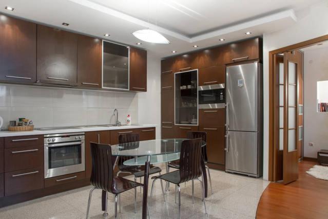 eine Küche mit einem Tisch und Stühlen sowie einem Kühlschrank in der Unterkunft Opera House Apartments in Vilnius