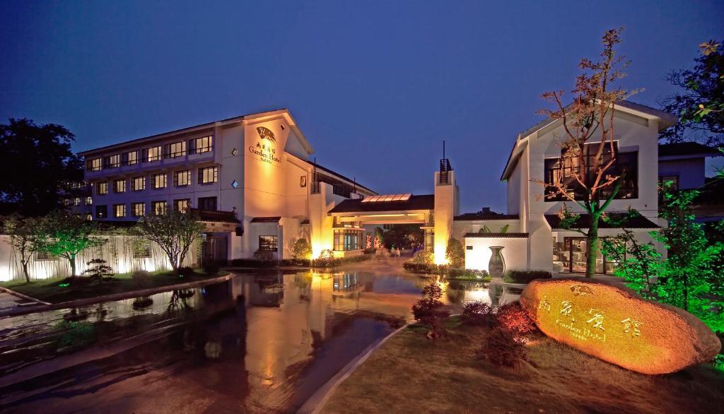 a building with a pool of water in front of it at Garden Hotel Suzhou in Suzhou